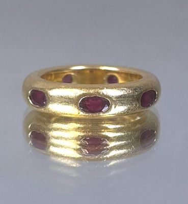 a close up of a gold ring with red stones