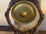 a large metal gong on a stand on a wooden floor