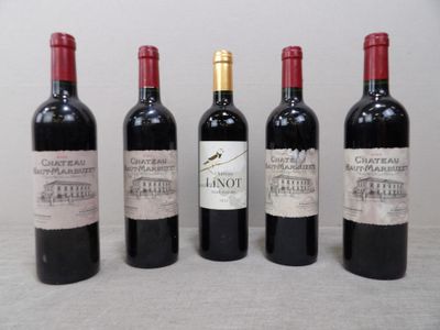 quatre bouteilles de vin rouge sont alignées sur une table
