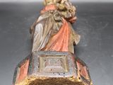 une figurine ancienne représentant une femme tenant un panier de fleurs
