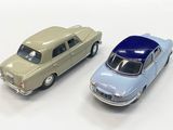 two toy cars sitting next to each other on a white surface