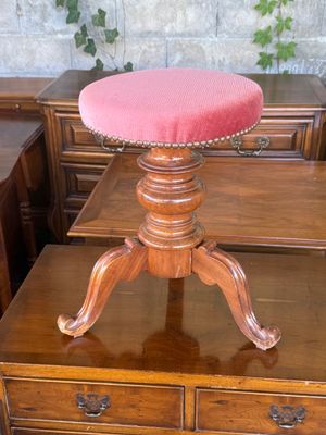 a wooden table with a pink stool on top of it