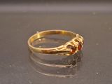 a gold ring with a red stone in it