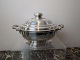a silver plate with a lid sitting on a marble table