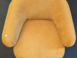 an orange chair sitting on top of a black carpeted floor
