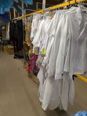 beaucoup de vêtements suspendus à une étagère dans une pièce