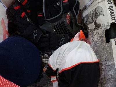 a pile of clothes and a backpack sitting on the ground