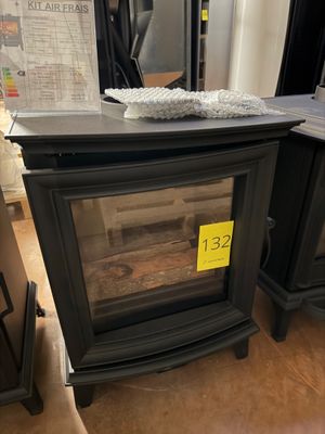 a black stove with a glass door in the middle of the room