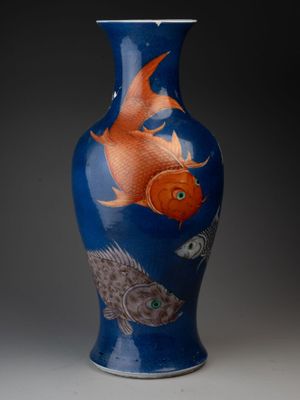 un vase bleu orné d'un motif représentant un poisson rouge
