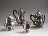 four pieces of silver tea and coffee set on a white surface