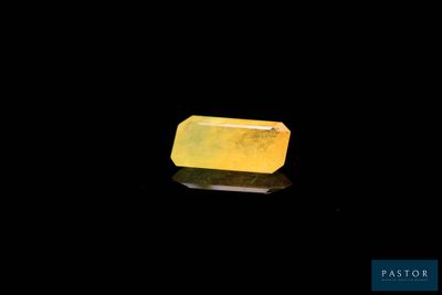a yellow jade stone on a black surface