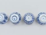 three blue and white vases are lined up on a white surface