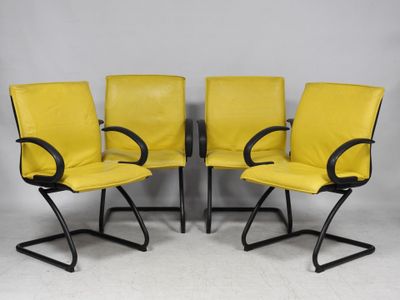 a set of four yellow leather office chairs with black metal legs