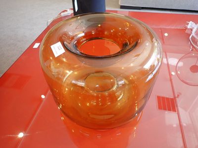 un vase en verre posé sur une table recouverte d'une nappe rouge