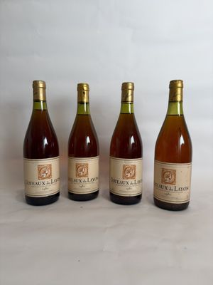 four bottles of wine are lined up on a white surface