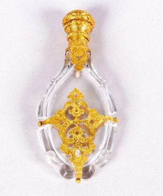 a close up of a gold and clear glass pendant on a white surface