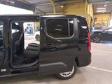 a black van parked in a garage with its doors open
