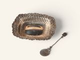 a silver plate with a spoon and a spoon rest on it