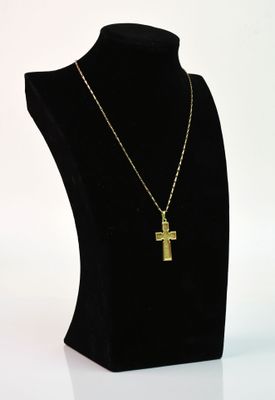 un mannequin noir orné d'une croix en or