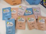 several packets of baby food are sitting on a table next to a bag of baby food