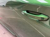 a close up of a car door handle on a green car