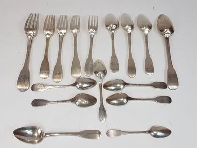 a lot of spoons and forks laid out on a table