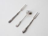 three forks and spoons sitting on a white surface with a spoon and knife