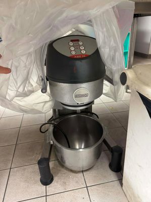 une personne qui se tient à côté d'un mixeur