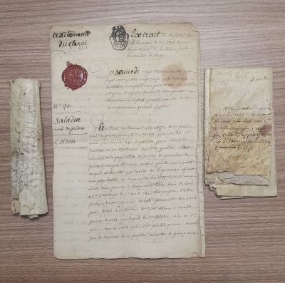 un morceau de papier portant un cachet de cire et un morceau de papier sur lequel est apposé un cachet de cire
