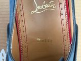blue leather shoes with red stitching on the sole of them