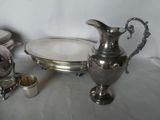 a silver plate and a silver pitcher on a table