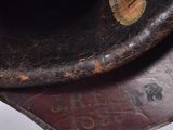 a close up of a brown hat with a tag on it