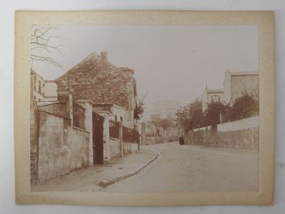 an old photo of a person walking down a street in an old town