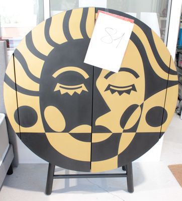 un soleil jaune et noir peint sur la façade d'une vitrine en bois