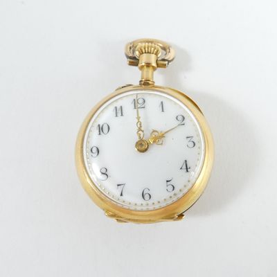 a gold pocket watch with a white face on a white surface