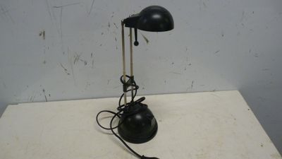 une lampe noire posée sur une table blanche