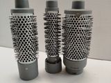 three different types of hair brushes sitting on top of a table
