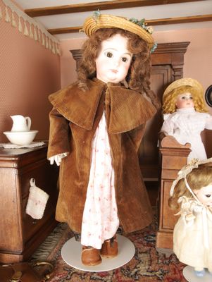 two dolls that are standing next to each other in a room