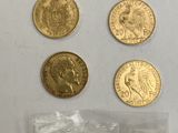 un gros plan sur un sac de pièces d'or posé sur une surface blanche