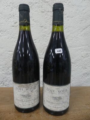 deux bouteilles de vin posées sur une table l'une à côté de l'autre