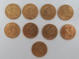six types différents de pièces d'or sur une surface blanche