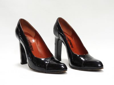 une paire de chaussures noires à talons hauts posée sur une surface blanche