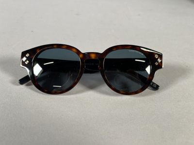 sunglasses on a table with a white table cloth and a white background