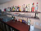 many bottles and glasses on the shelves in the bar