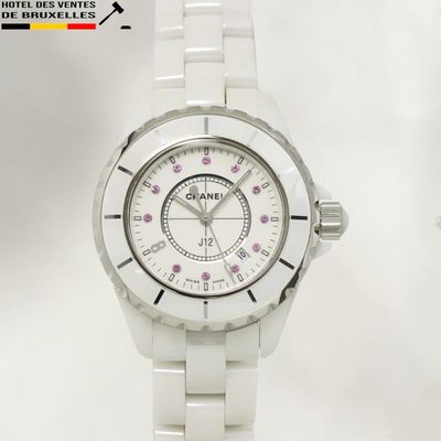 une montre blanche avec un cadran rose sur fond blanc