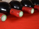 several bottles of wine are lined up on a red table