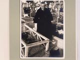 une photo en noir et blanc d'un homme debout dans un cimetière