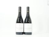 deux bouteilles de vin rouge posées l'une à côté de l'autre sur une surface blanche