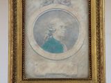 an old picture of a man in a blue shirt in a gold frame