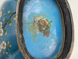 a blue vase with flowers on it sitting on a table